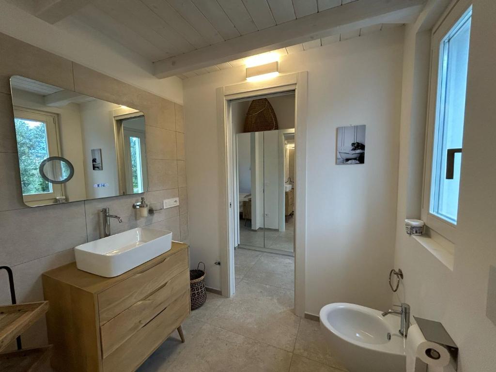 une salle de bain avec un lavabo et un miroir dans l'établissement Exclusive Villa Bianca, à Cugnana