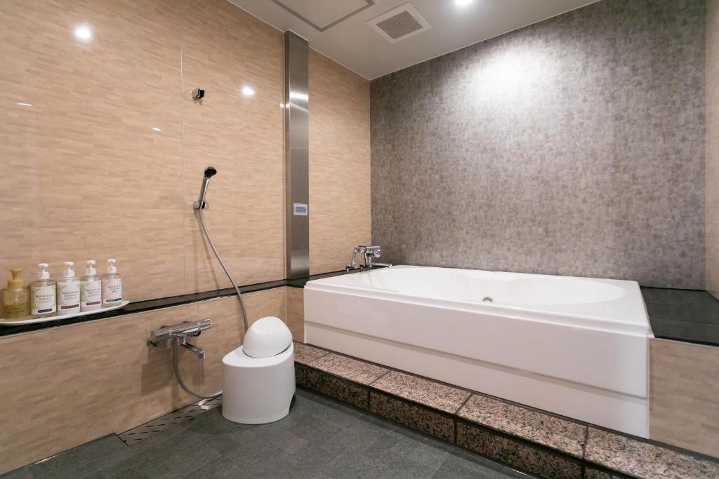 La salle de bains est pourvue d'une grande baignoire et de toilettes. dans l'établissement Hotel TEMARI Matsumoto, à Matsumoto 37 autres photos
