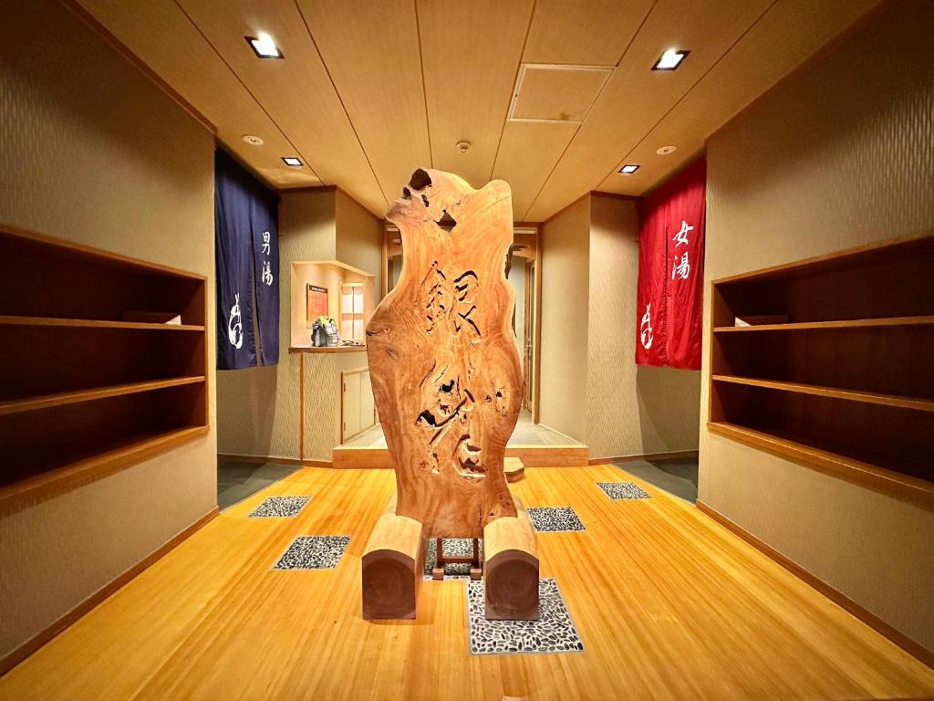 une sculpture en bois d'une femme dans une pièce dans l'établissement Ginka, à Toyooka