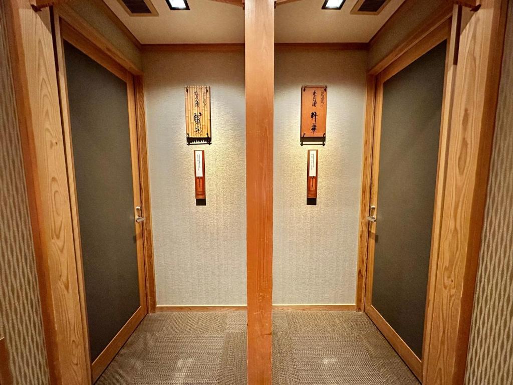 un couloir avec des portes et des fenêtres dans un bâtiment dans l'établissement Ginka, à Toyooka