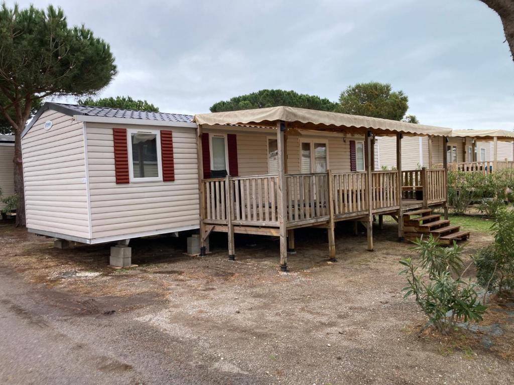 une petite maison avec un porche et une terrasse dans l'établissement Mobil Home 4-6 personnes, à Canet