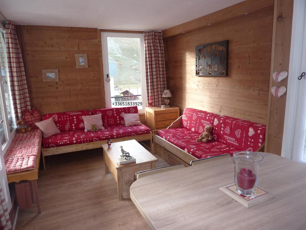 un salon avec des canapés rouges et une table dans l'établissement Prariond 5, à Tignes