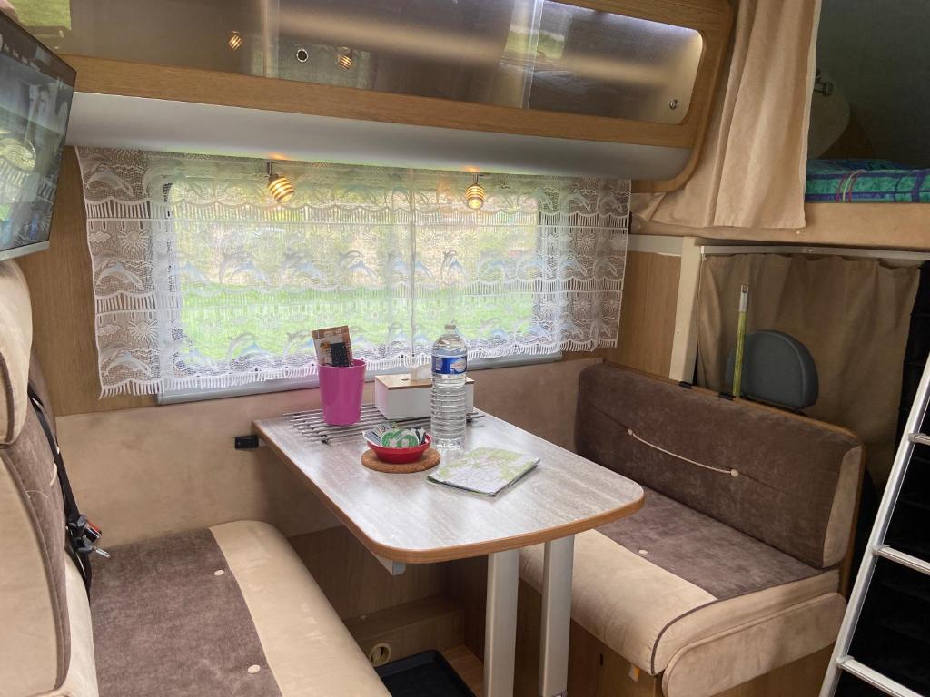 Une petite table à l'arrière d'un véhicule dans l'établissement Camping-car au Charme de la Forêt Circuit des 25 Bosses, à Le Vaudoué