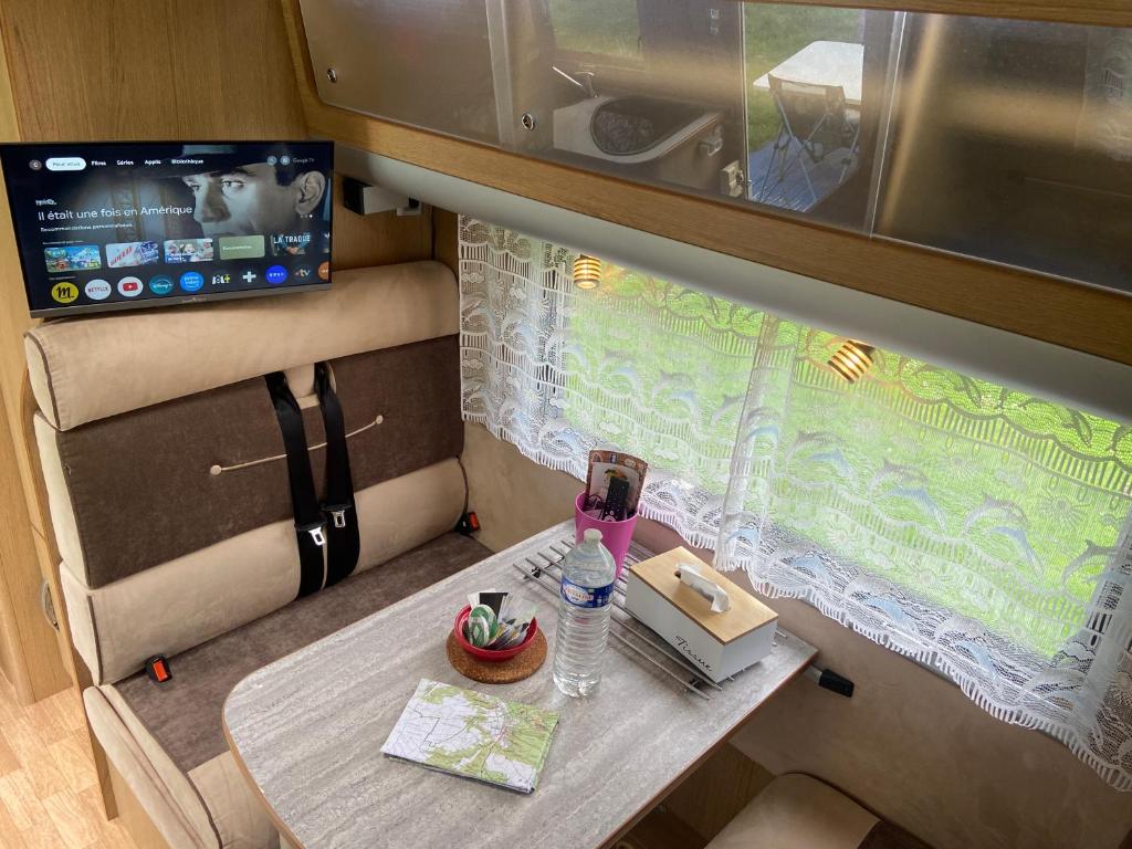 - une petite table dans un bar avec un verre dans l'établissement Camping-car au Charme de la Forêt Circuit des 25 Bosses, à Le Vaudoué
