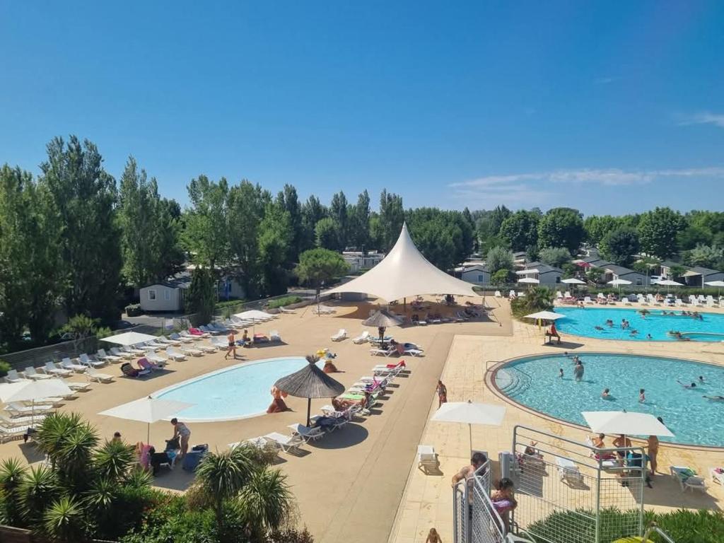un complexe avec une piscine et beaucoup de personnes dans l'établissement Mobile home Bora bora, à Vias