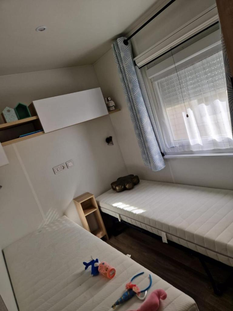une petite chambre avec deux lits et une fenêtre dans l'établissement Mobile home Bora bora, à Vias