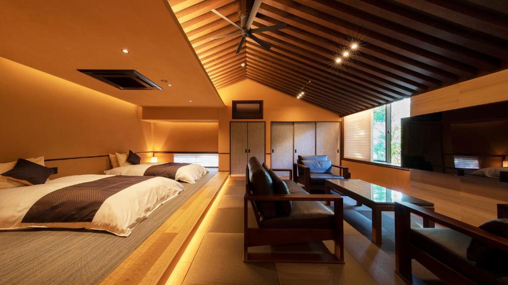 une chambre avec un lit, un bureau et une télévision dans l'établissement Tetsuka Ryokan, à Satsuma