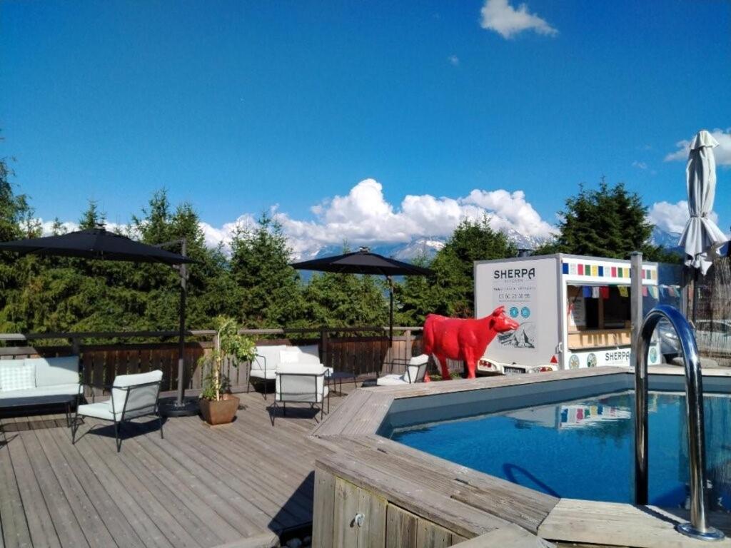 une statue de taureau rouge près d'une piscine dans l'établissement Chalet Les Rhodos, à Cordon