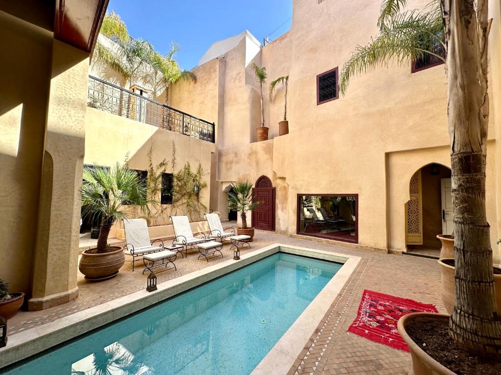 une maison avec une piscine dans une cour dans l'établissement Riad Dar Karma, à Marrakech