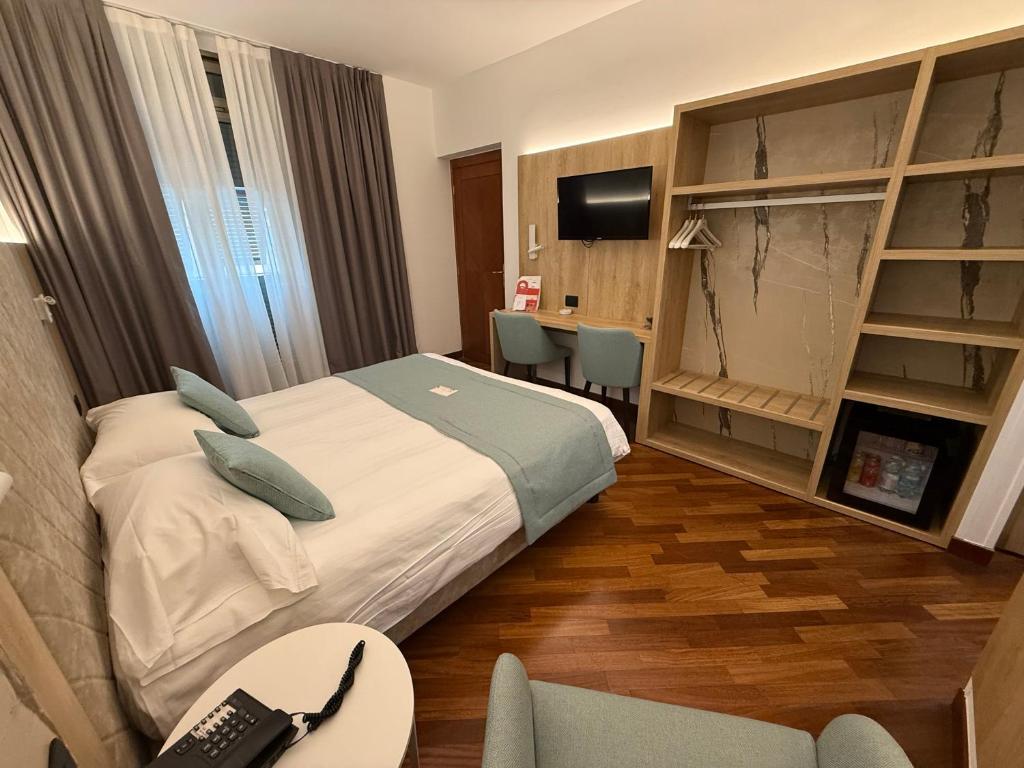 une chambre d'hôtel avec un lit et un bureau dans l'établissement Hotel Parigi & Spa, à Bordighera