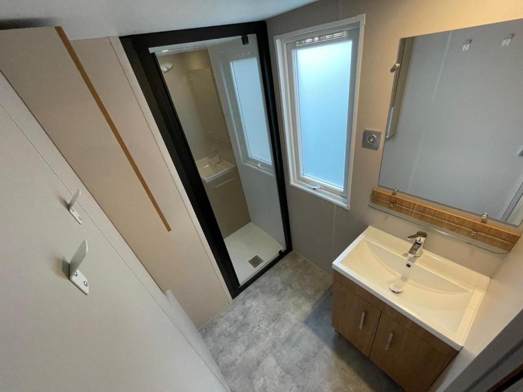 une salle de bain avec un lavabo et un miroir dans l'établissement Mobilhome neuf à Camping Domaine l'Ile d'Or à Saint Raphaël, à Saint-Raphaël