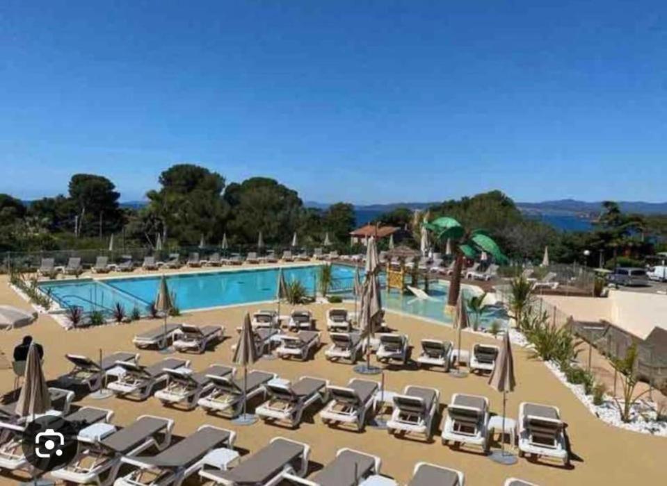 un complexe avec de nombreuses chaises longues et une piscine dans l'établissement Mobilhome neuf à Camping Domaine l'Ile d'Or à Saint Raphaël, à Saint-Raphaël