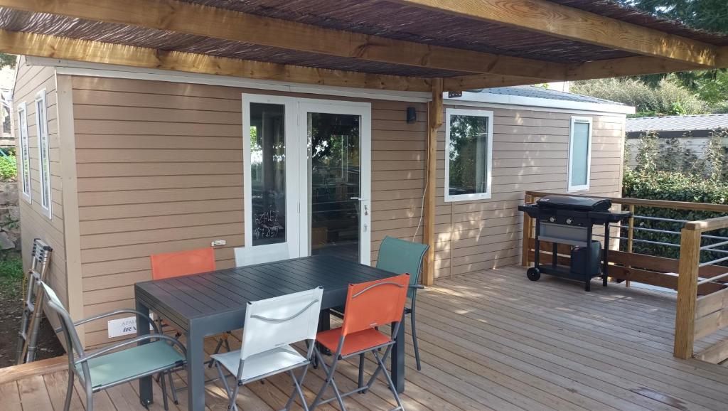 une terrasse avec une table, des chaises et un grill dans l'établissement Mobilhome neuf à Camping Domaine l'Ile d'Or à Saint Raphaël, à Saint-Raphaël
