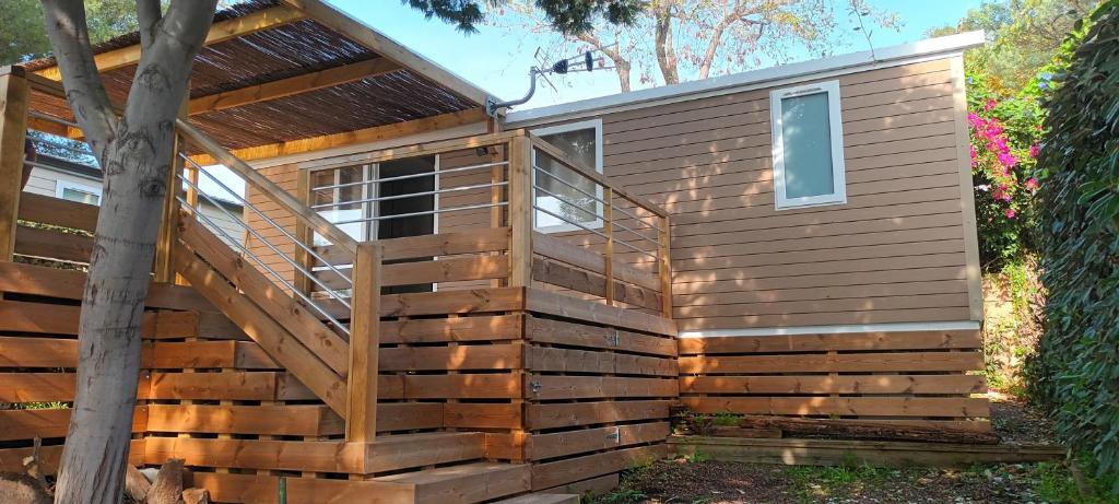 une grande cabane en bois avec un escalier dans une cour dans l'établissement Mobilhome neuf à Camping Domaine l'Ile d'Or à Saint Raphaël, à Saint-Raphaël