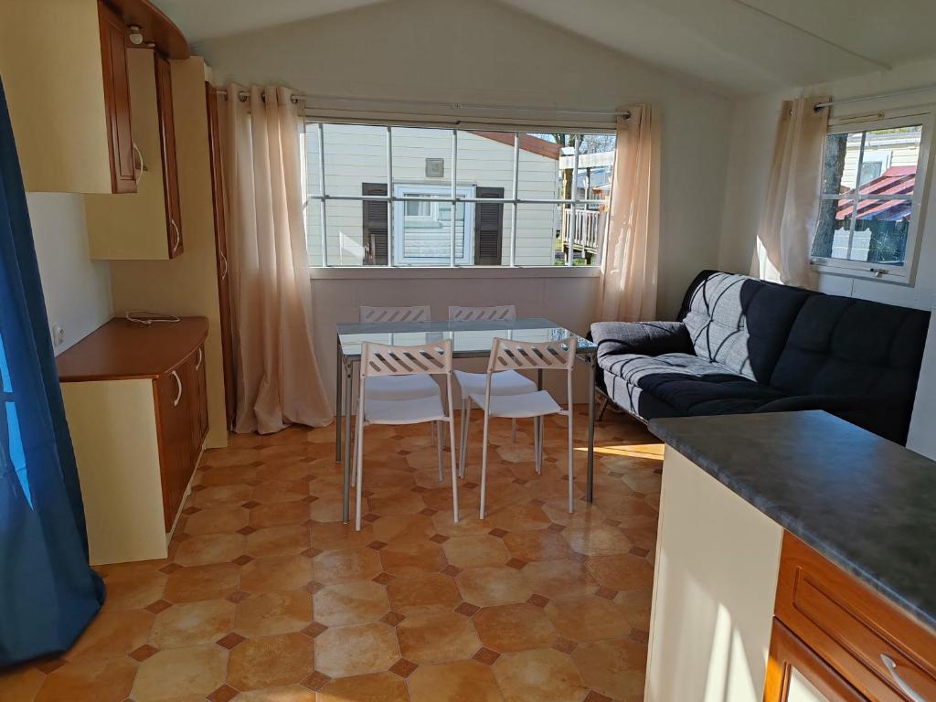 un petit salon avec une table et un canapé dans l'établissement Mobil Home Le Salicorne, à Noyelles-sur-Mer