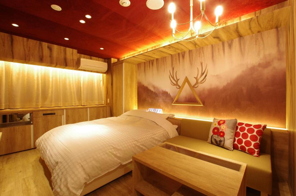 une chambre avec un lit et un banc dans l'établissement Susukino LOVE HOTEL1-Adult Only, à Sapporo