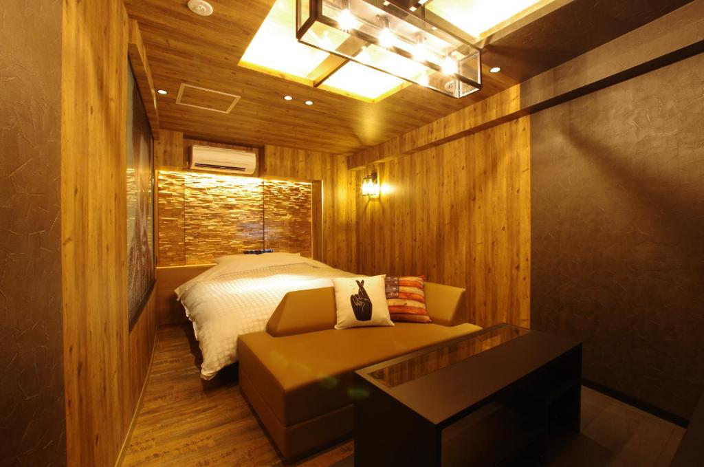 une chambre avec un lit et un canapé dans l'établissement Susukino LOVE HOTEL1-Adult Only, à Sapporo