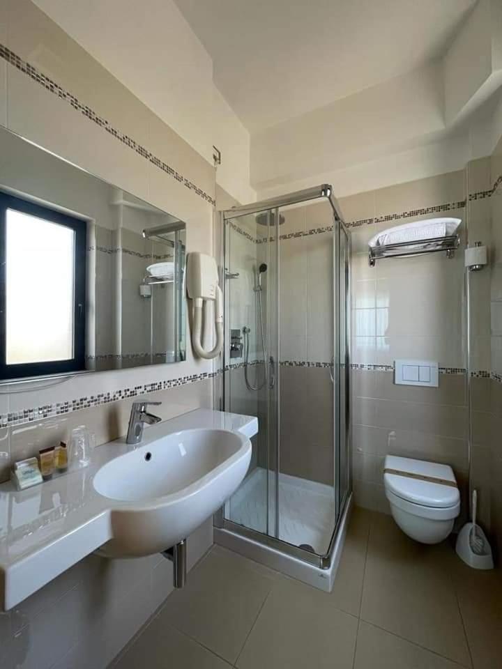 une salle de bain avec un lavabo, une douche et des toilettes dans l'établissement Hotel Maja, à Pescara