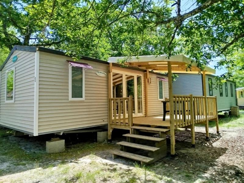 une petite maison avec un porche et une terrasse dans l'établissement Camping le Sen Yan, à Mézos