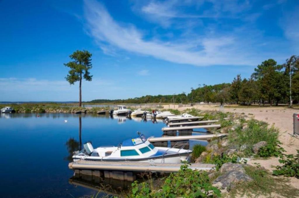 un groupe de bateaux amarrés à un quai sur un lac dans l'établissement chez Sodam by siblu, à Parentis-en-Born