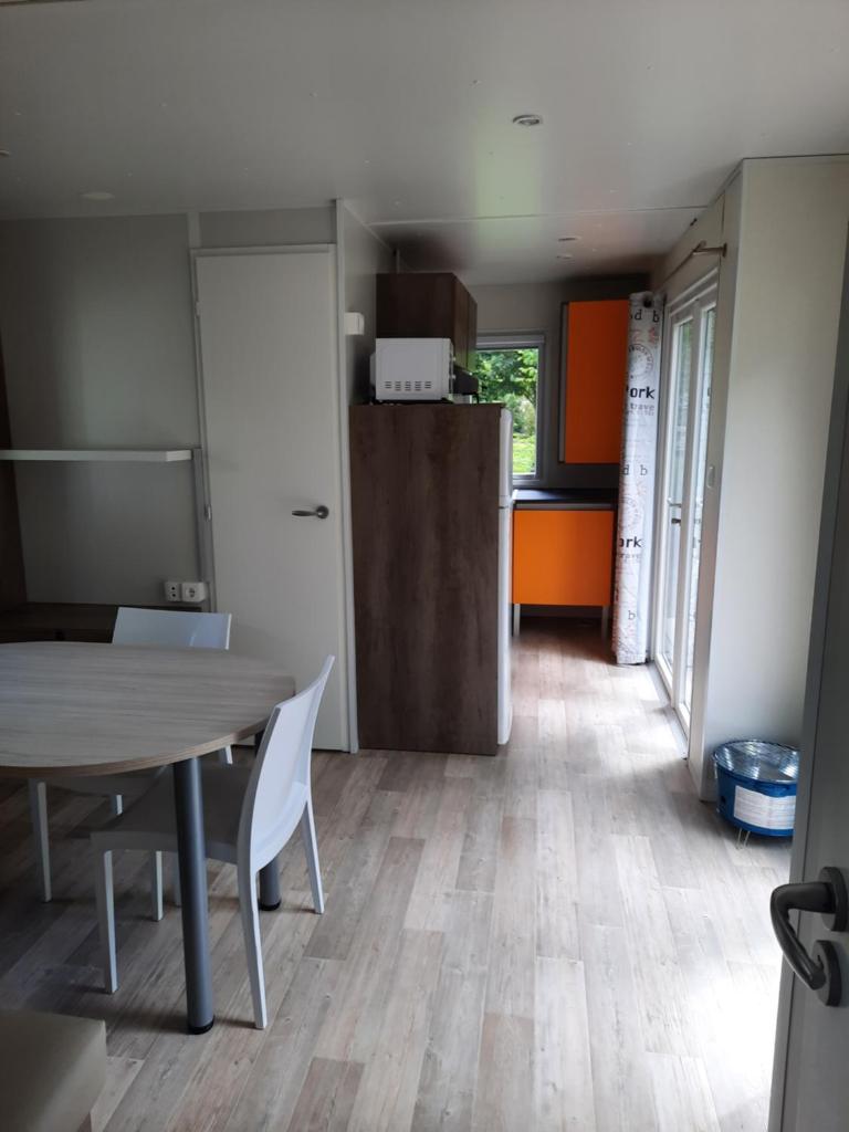 une cuisine et une salle à manger avec une table et un réfrigérateur dans l'établissement Camping de Salviac, à Salviac