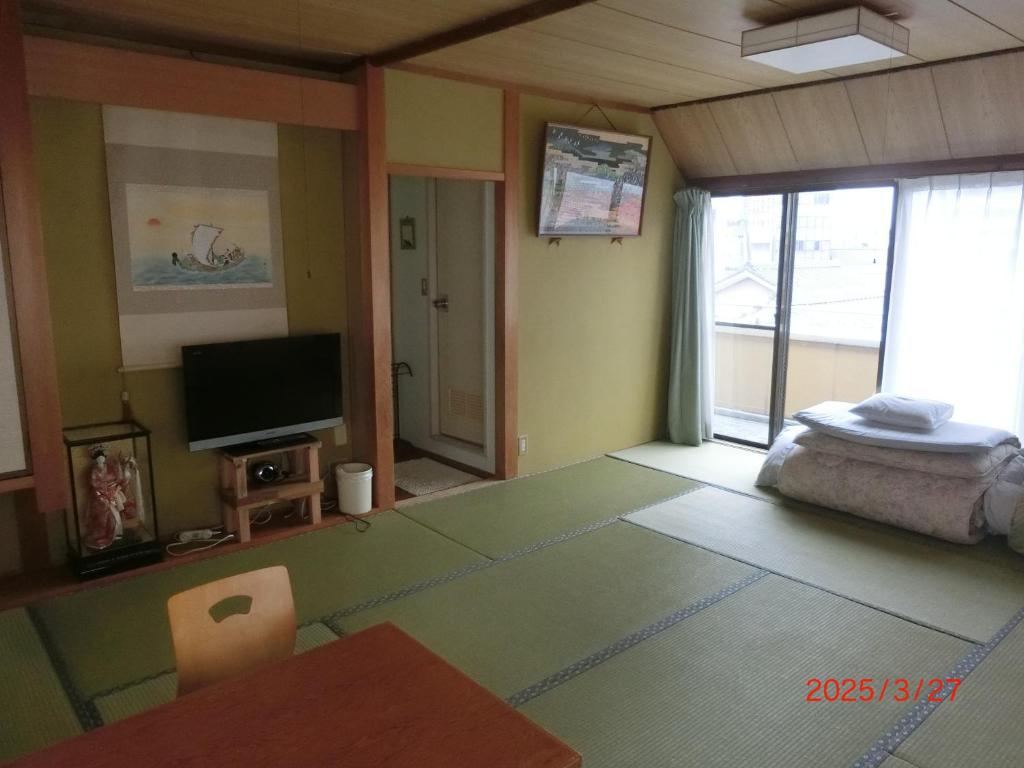 un salon avec une télévision et un canapé dans l'établissement Mizuhokan, à Ise