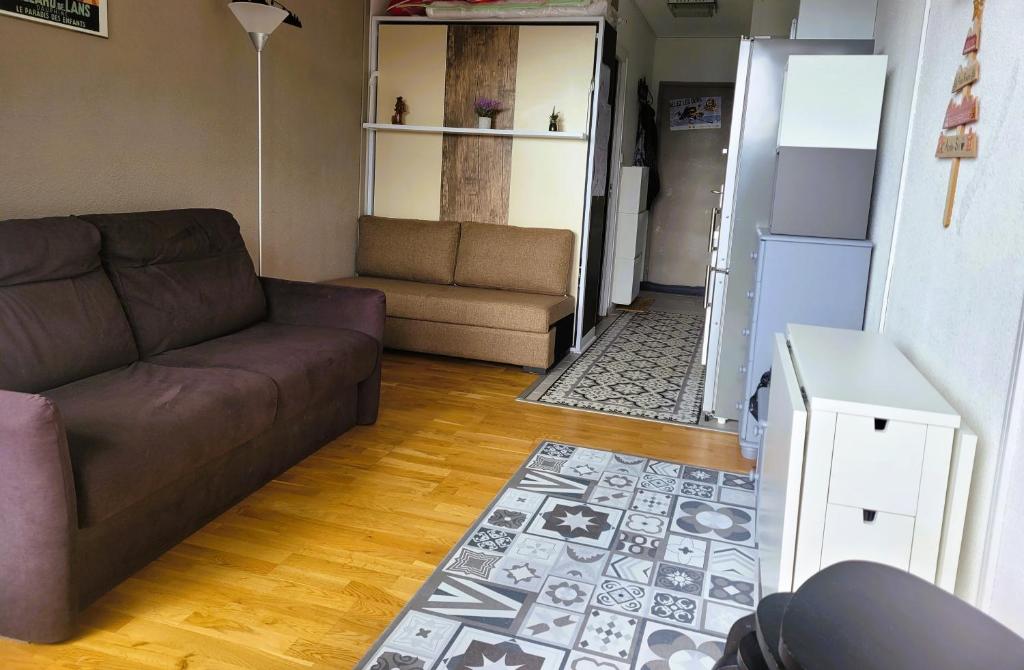 - un salon avec un canapé et un réfrigérateur dans l'établissement STUDIO plein sud "Les Arolles" Balcon de VILLARD DE LANS, à Villard-de-Lans