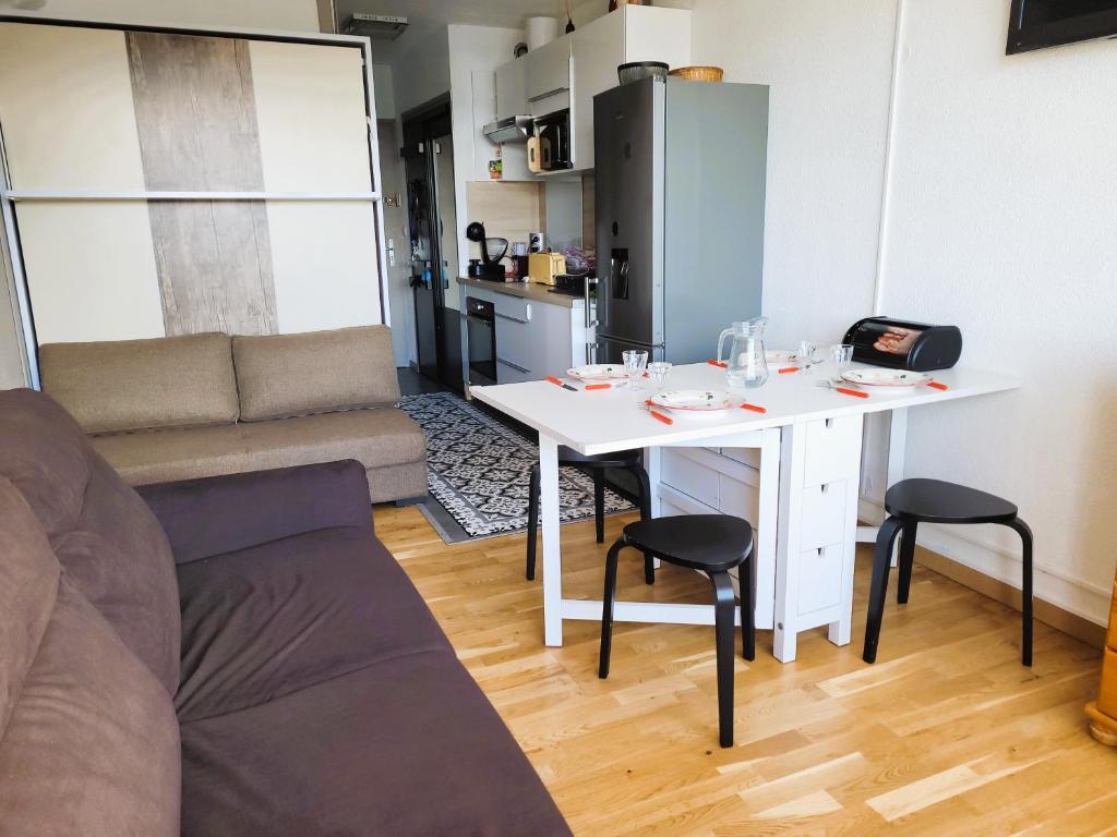 un salon avec une table blanche et un canapé dans l'établissement STUDIO plein sud "Les Arolles" Balcon de VILLARD DE LANS, à Villard-de-Lans