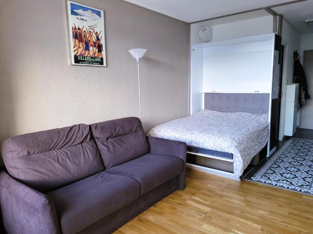 un salon avec un canapé et un lit dans l'établissement STUDIO plein sud "Les Arolles" Balcon de VILLARD DE LANS, à Villard-de-Lans