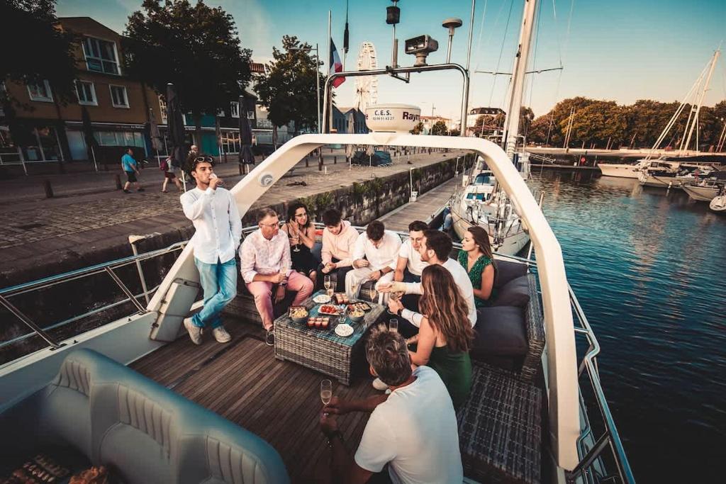 Un groupe de personnes assises autour d'une table sur un bateau dans l'établissement Yacht EVASION La Rochelle - Bateau insolite, à La Rochelle
