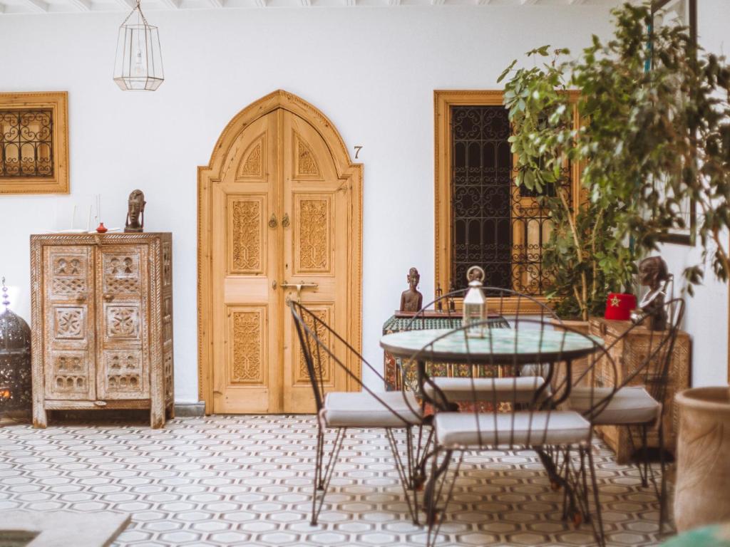 Cette chambre dispose d'une table et d'une porte en bois. dans l'établissement Riad Le Petit Joyau, à Marrakech