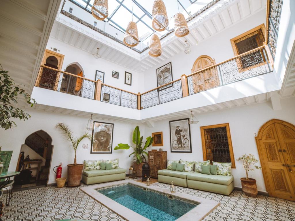 - un salon avec une piscine au milieu d'un bâtiment dans l'établissement Riad Le Petit Joyau, à Marrakech