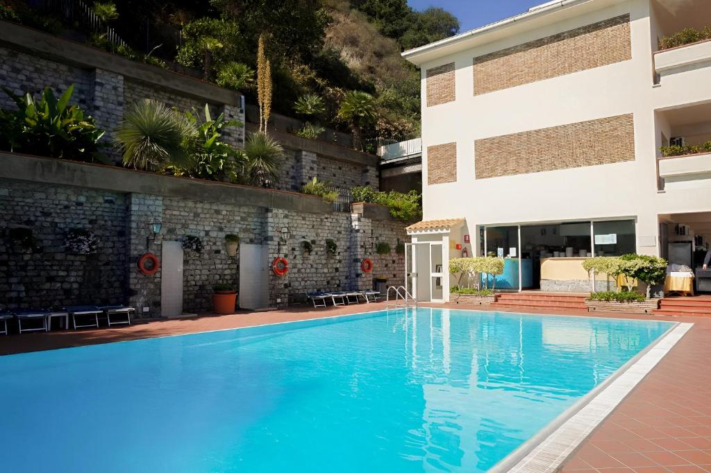une piscine devant un bâtiment dans l'établissement HOTIDAY Taormina Mare, à Taormine