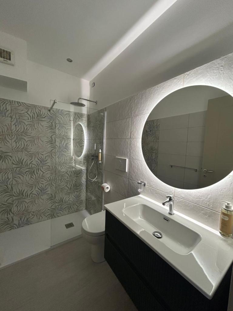 une salle de bain avec un lavabo, des toilettes et un miroir dans l'établissement Mediterranean Boutique Hotel, à Tropea