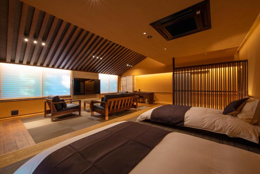 une chambre avec un lit et un bureau dans une pièce dans l'établissement Tetsuka Ryokan, à Satsuma