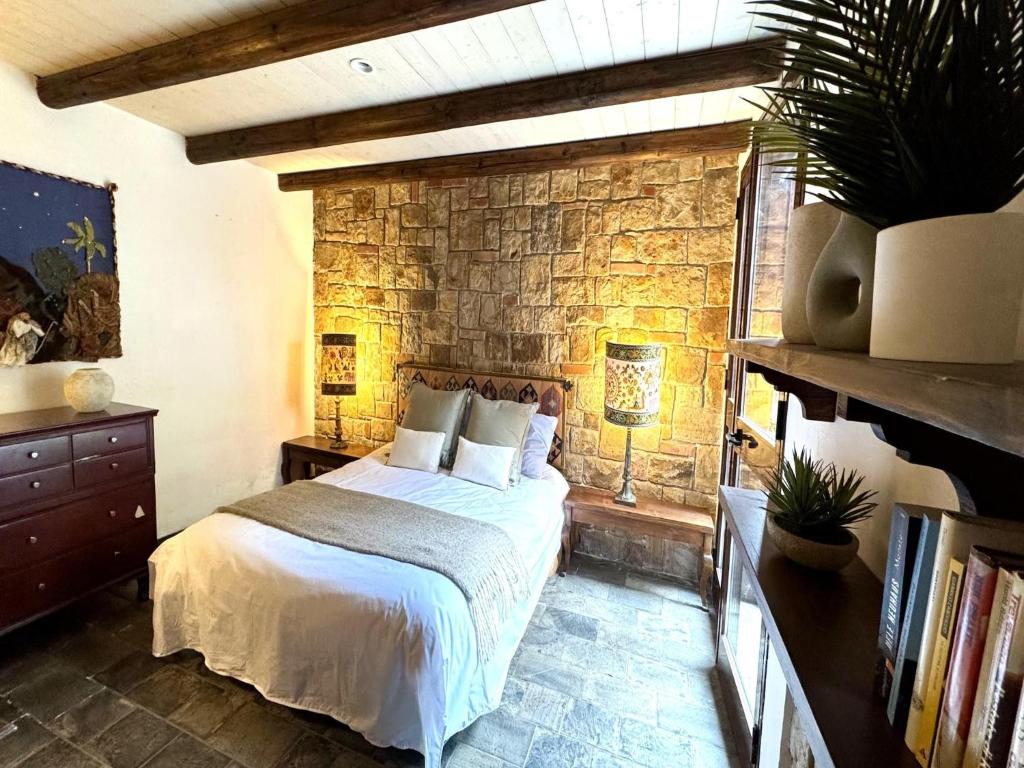 une chambre avec un lit et un mur de briques dans l'établissement Villa in Cefalù with Pool and Forest Retreat, à Castelbuono 32 autres photos