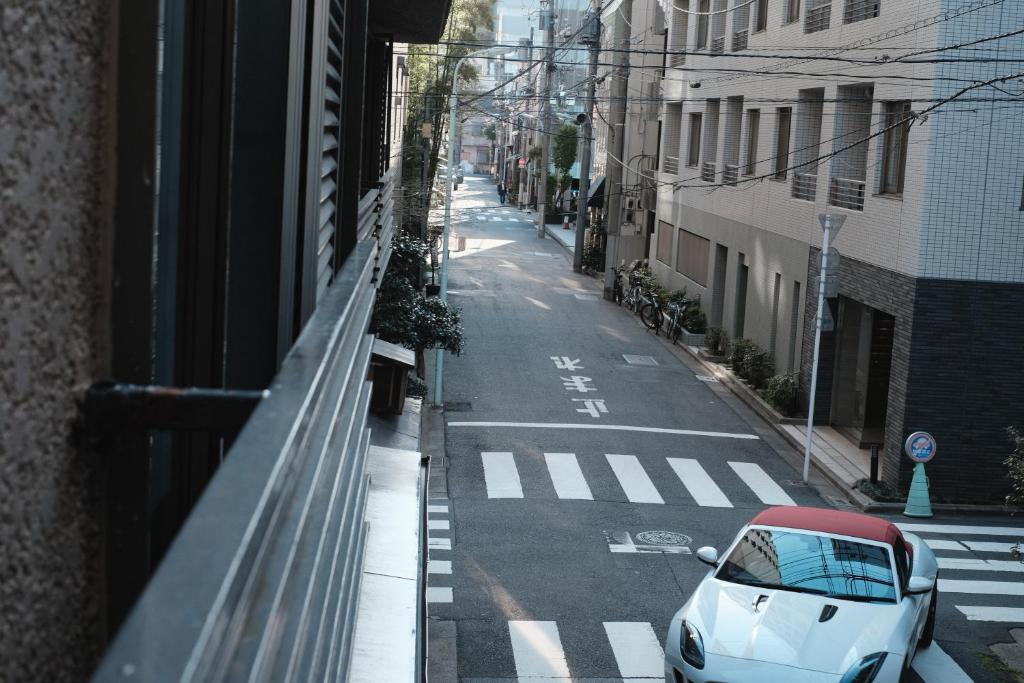 une voiture blanche garée sur le côté d'une rue dans l'établissement Ito Ryokan, à Tokyo
