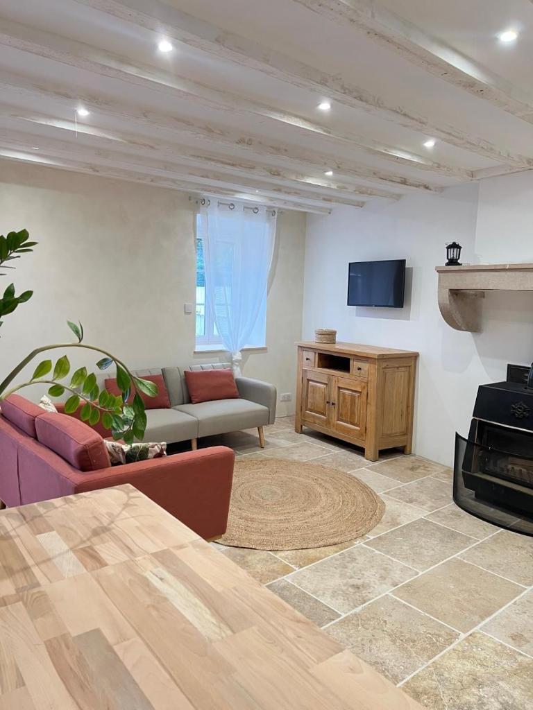 un salon avec un canapé et une télévision dans l'établissement Gîte, à Saint-Bénigne 22 autres photos
