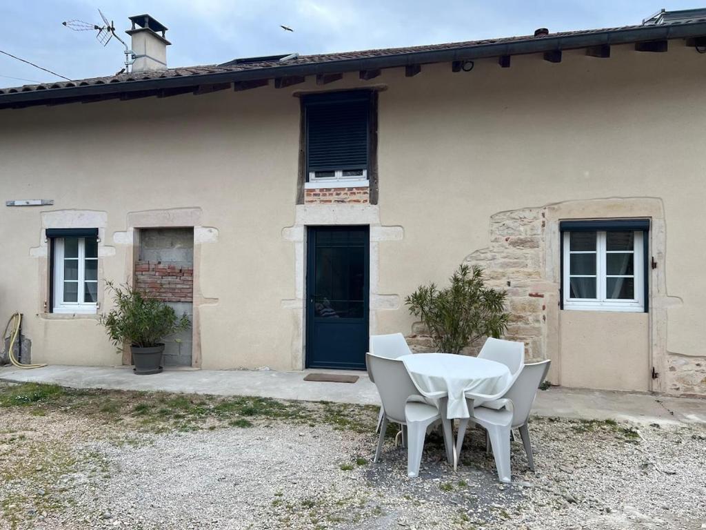 une table et des chaises devant une maison dans l'établissement Gîte, à Saint-Bénigne