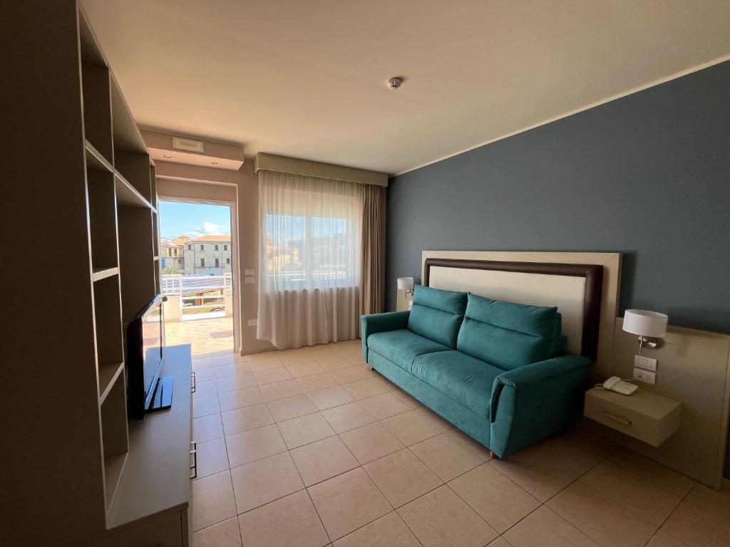 un salon avec un canapé bleu et une télévision dans l'établissement Mediterranean Boutique Hotel, à Tropea