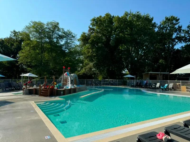 - une piscine avec une fontaine au milieu dans l'établissement Camping Les Franquettes - Aquatique Vacances, à Grayan-et-lʼHôpital