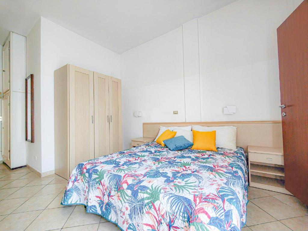- une chambre avec un lit doté de draps et d'oreillers colorés dans l'établissement Hotel Bruna, à Cesenatico