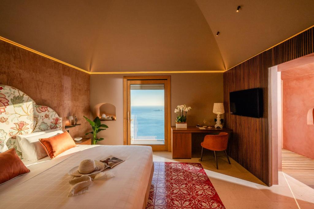 une chambre avec un grand lit avec vue sur l'océan dans l'établissement Antalia Boutique Hotel, à Positano
