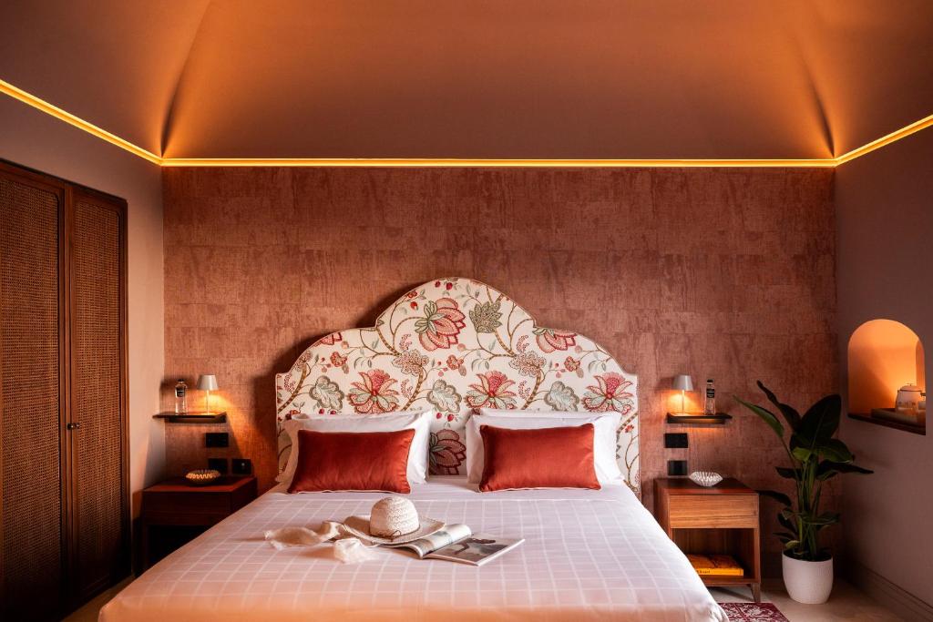 - une chambre avec un grand lit et une tête de lit fleurie dans l'établissement Antalia Boutique Hotel, à Positano