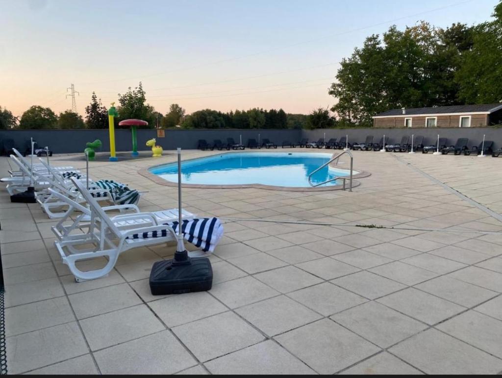 une piscine avec un tas de chaises autour dans l'établissement Lydia's Mobilhome am Europa-Park Rulantica, à Boofzheim