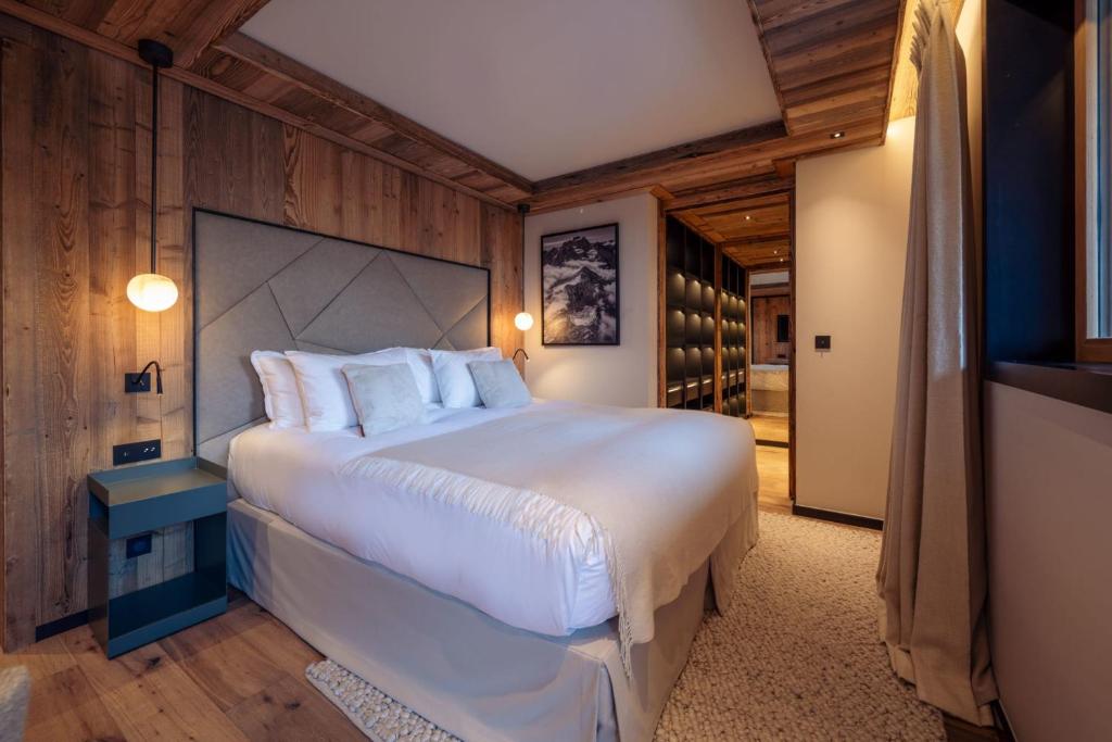 une chambre avec un grand lit blanc dans une pièce dans l'établissement Antarès URSA 403 - luxury apartment ski inski out, à Méribel 12 autres photos