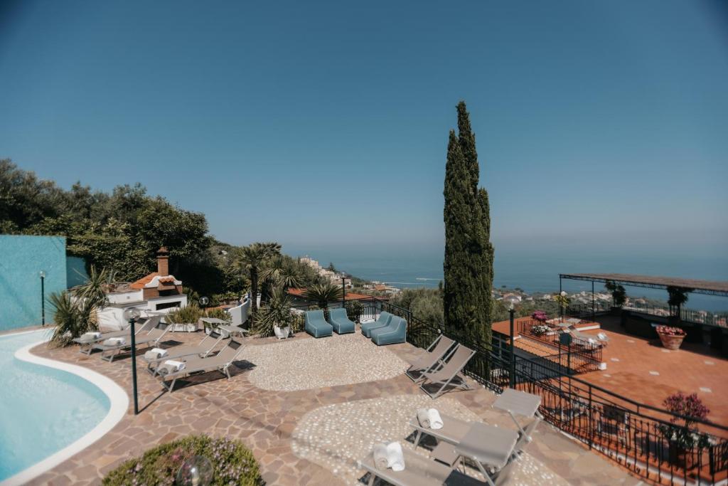 un complexe avec une piscine, des chaises et un arbre dans l'établissement Villa Bianca Sorrento, à Sorrente