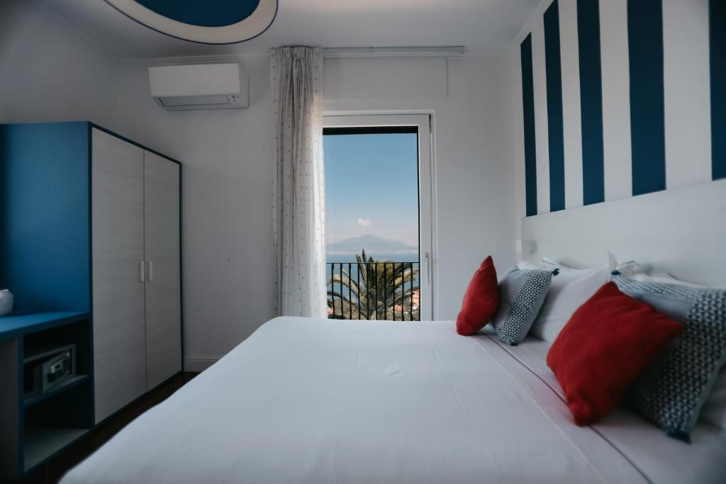une chambre avec un grand lit blanc avec des oreillers rouges dans l'établissement Villa Bianca Sorrento, à Sorrente