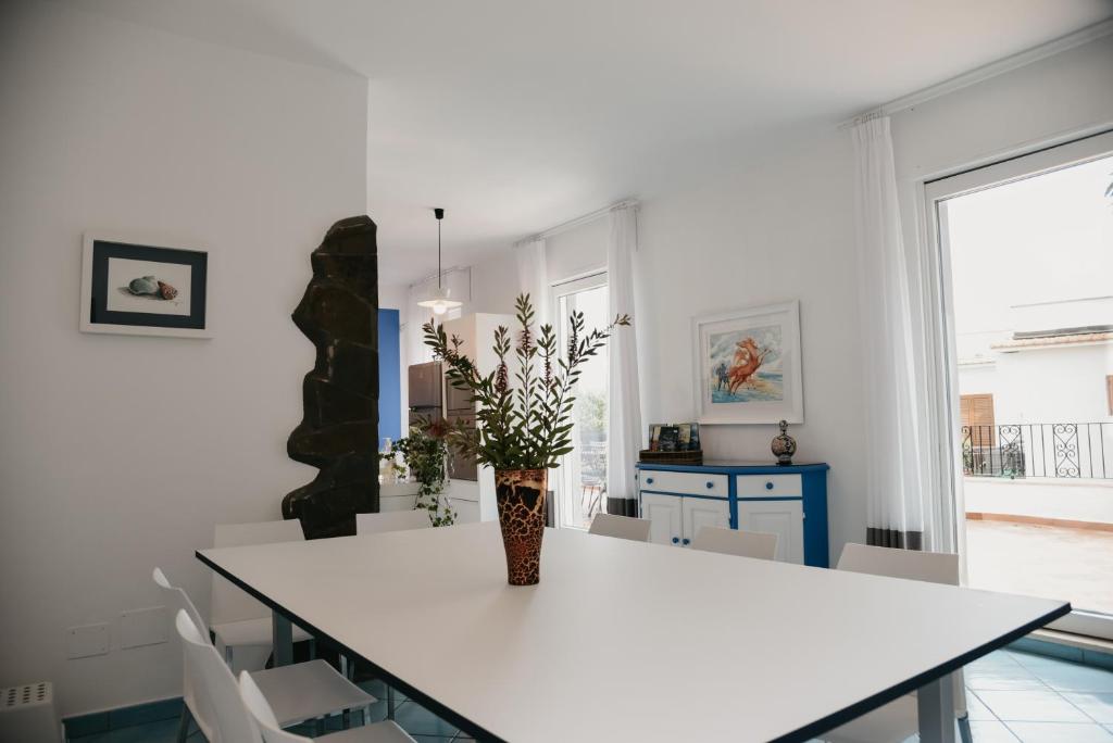 - une cuisine blanche avec une table et un vase dans l'établissement Villa Bianca Sorrento, à Sorrente