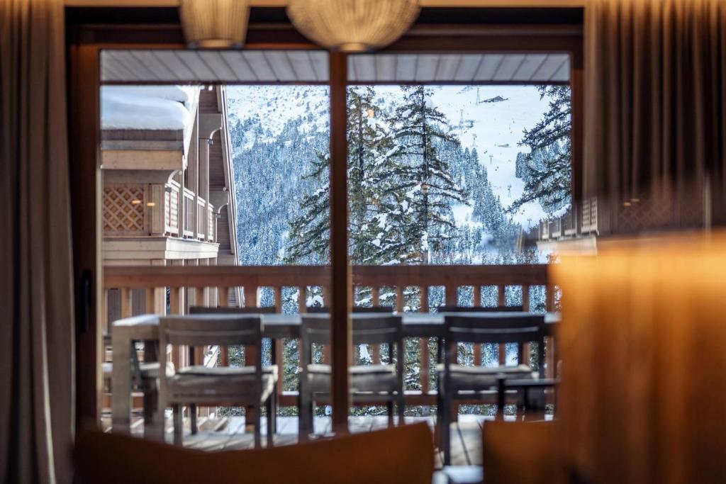 d'un balcon offrant une vue sur une montagne enneigée depuis une fenêtre. dans l'établissement Antarès URSA 403 - luxury apartment ski inski out, à Méribel